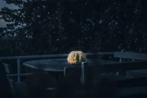 Leuchtender Halloween-Kürbis auf einem dunklen Tisch als stimmungsvolle Dekoration